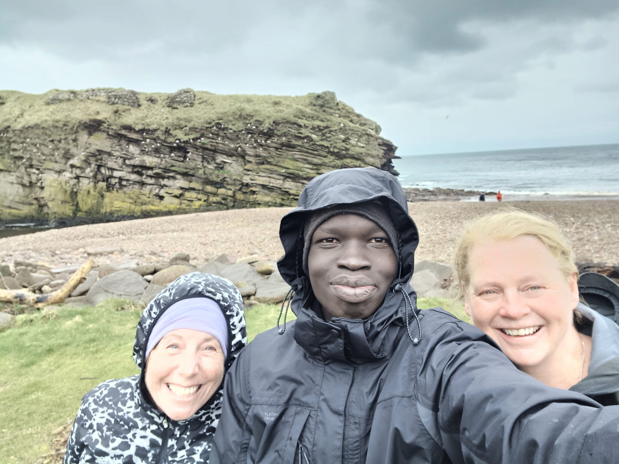 Picture of three individuals by the beach